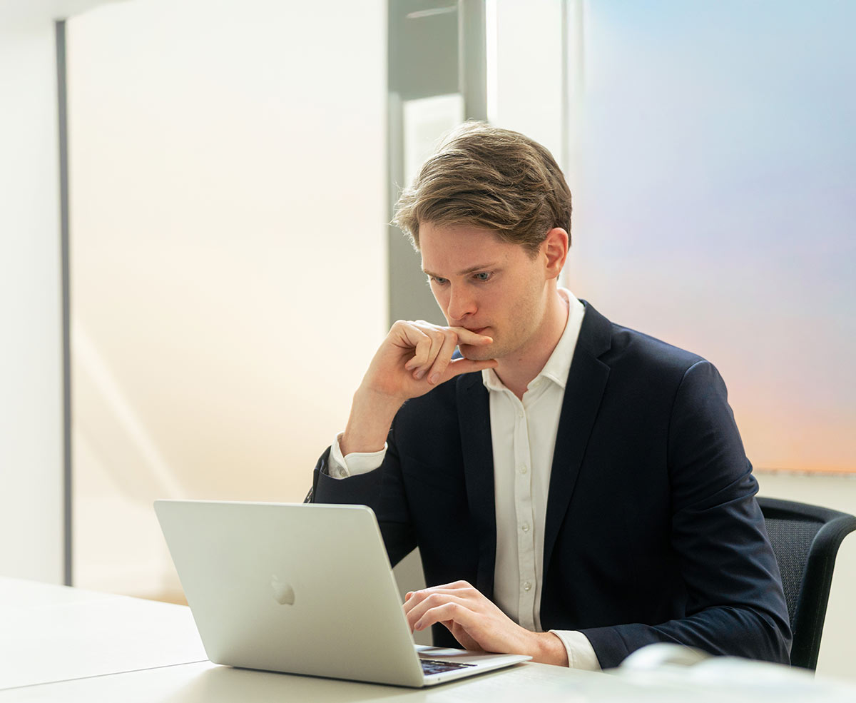 Ein Interim Manager von Aurum sitzt in einem hell ausgeleuchtetem Büro vor seinem Laptop
